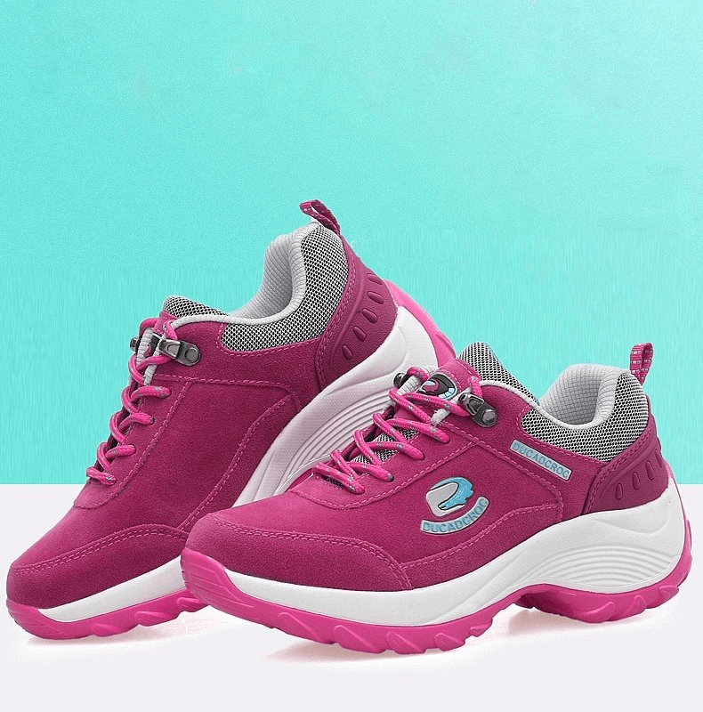 Vibrant pink women's sports sneakers with suede uppers, animal print accents, and lace-up closure, designed for comfort and stability.
